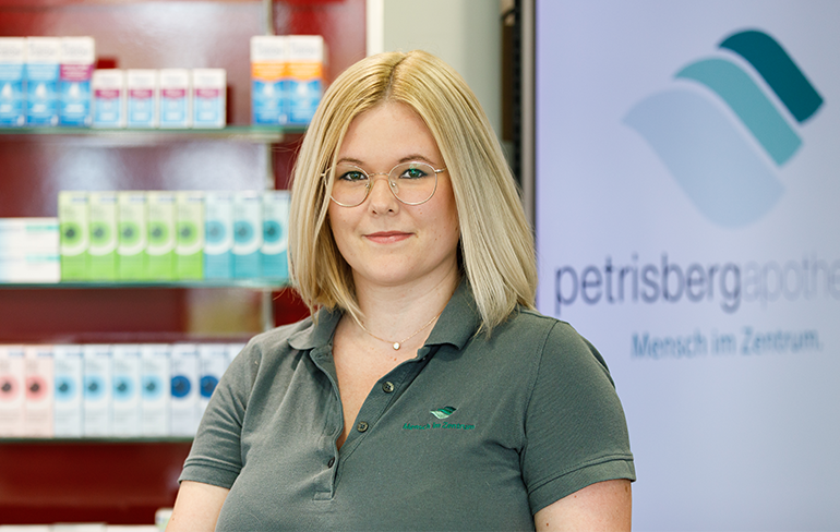 Eine Apothekerin der Petrisberg Apotheke steht vor einem Medikamentenregal.